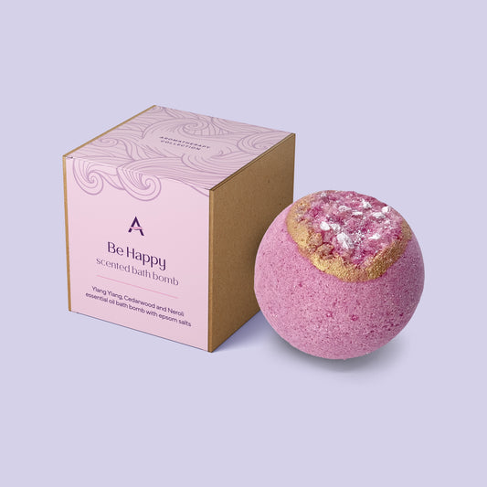 Be Happy bath bomb featuring uplifting ylang ylang, neroli, petitgrain and cedarwood essential oils, enriched with cocoa butter, kaolin clay, coconut milk and Epsom salts for a cheerful, nourishing bath.