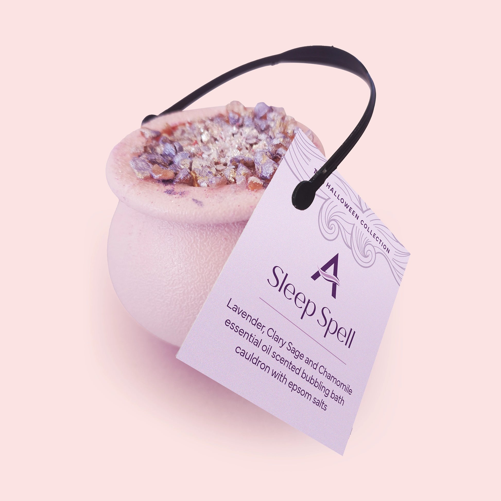 pink cauldron with bath bomb mix inside topped with lilac salts